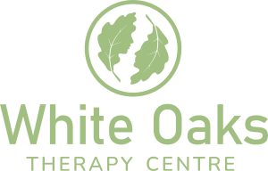Logo for White Oaks Therapy Centre featuring a circular emblem with green oak leaves and the text 'White Oaks Therapy Centre' beneath it
